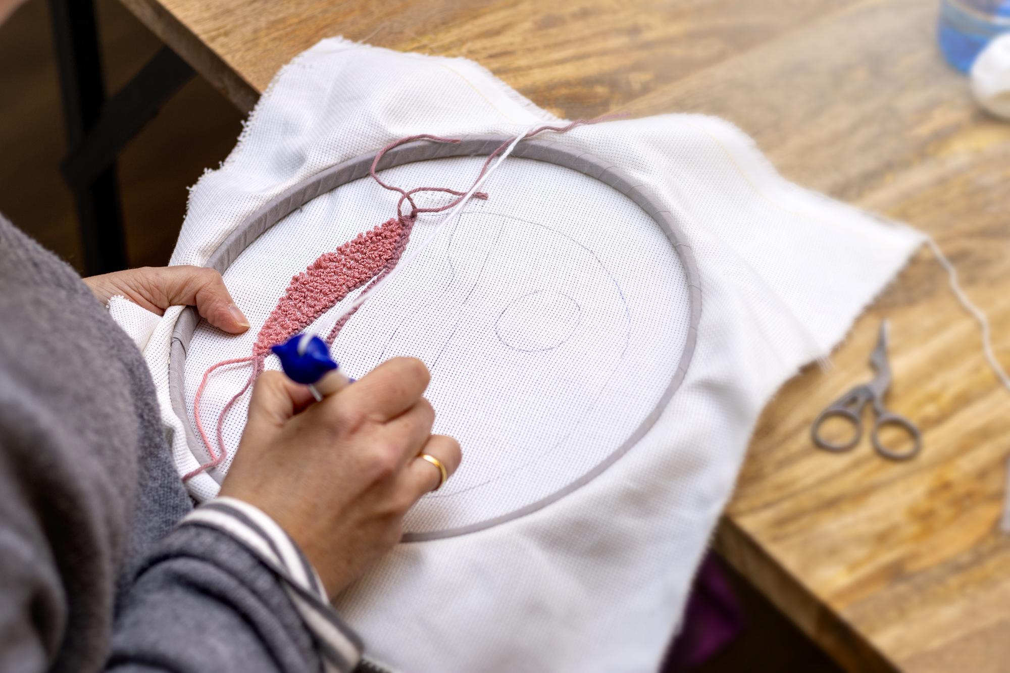 Workshop hands preparing hoop for embroidery